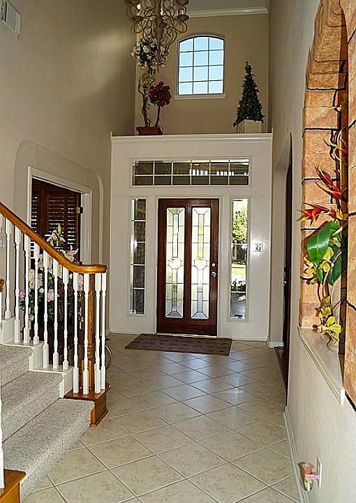 Two story entry hall with tiled floors, art ledge above front door & art niche...
