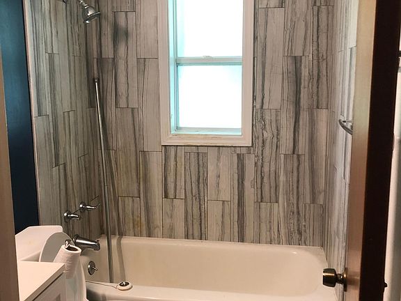 Well lit bathroom with shower and tub