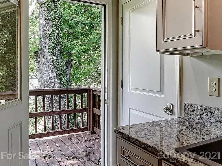 Patio outside kitchen with steps down to ample deck.