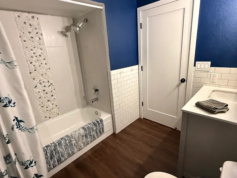 Shower and bath with new tile, shower curtain, and faucets