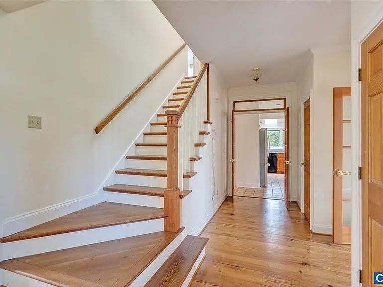The staircase and all the floors are reclaimed heartwood pine. They were refinished this summer. The banisters were custom built by the original owner.