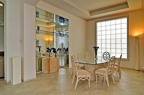 Formal Dining Room With Crown Moldings, Coffered Ceiling, And Glass Block Window