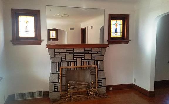 Living room has art glass windows flanking the electric fireplace, on the rear wall (reflected in th