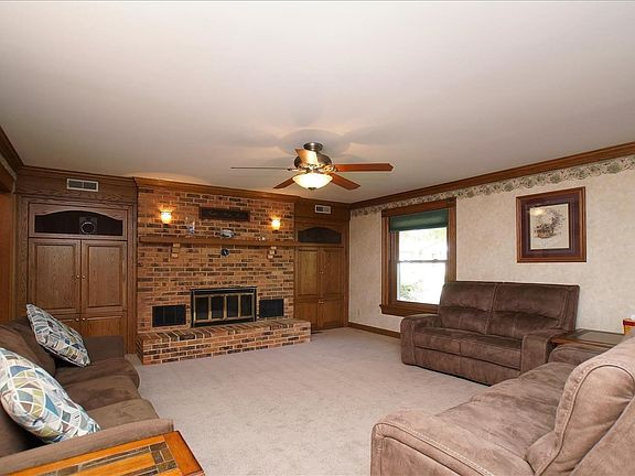 Generously sized living room with wood burning fireplace and built in cabinets/shelves