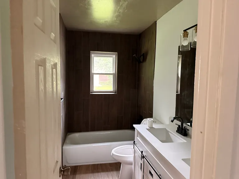 Newly renovated bathroom Ceramic wood look tile, new fixtures and sick