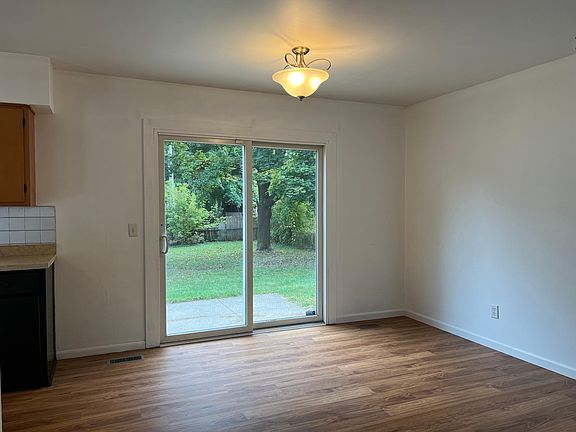 Dining room with slider that opens to backyard and cement patio
