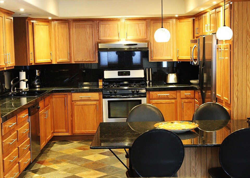 Custom kitchen with gas range and stainless steel appliances.