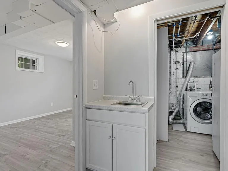 bottom floor - possible in-law suite - wet bar and doorways to bedroom and utility room