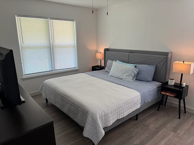 Primary bedroom with King bed. Dresser and 42" TV.