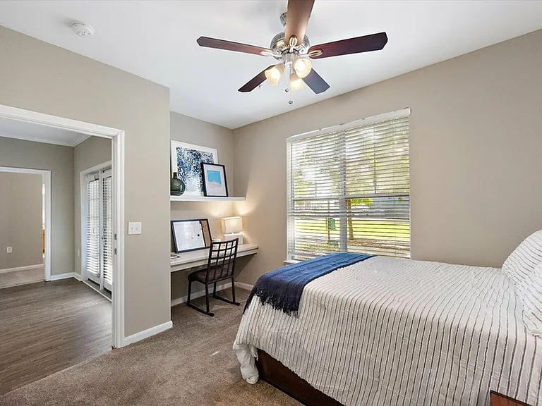 Enjoy a Cozy Bedroom with a Built-In Desk and Natural Light at Eagle Flatts Student Apartments in Hattiesburg