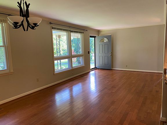 Living room photo taken from the kitchen area. Big beautiful windows let in lots of sun light and over looks the shaded front yard.
