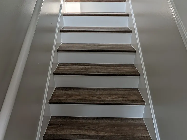 Staircase featuring rich wood treads and classic white risers