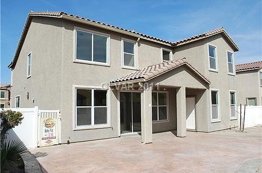 Back yard with patio area, partially covered.