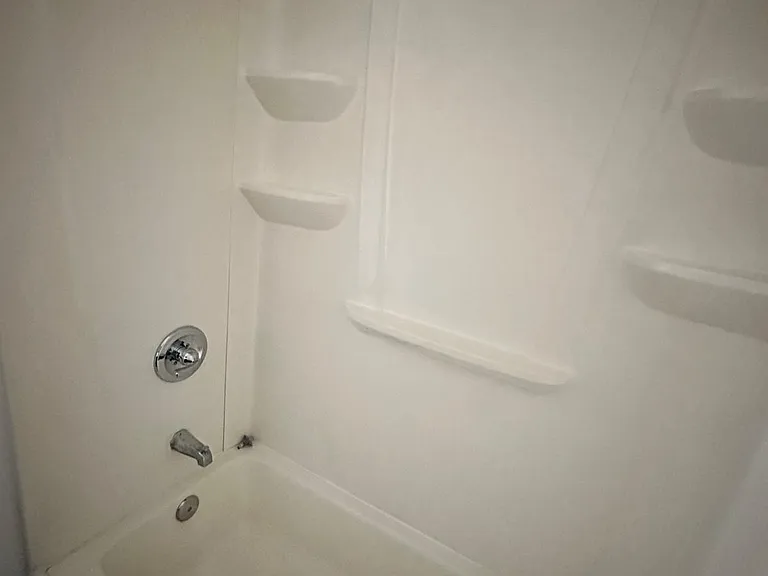 Bathroom with white subway tiled walls, tiled floors.