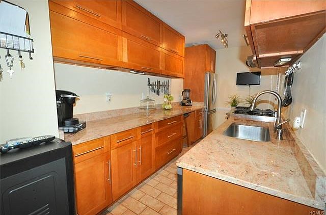 Fully renovated eat-in-kitchen with granite counters, custom cabinets and stainless steel appliances including a dishwasher, French door refrigerator and commercial grade range with stunning hood.
