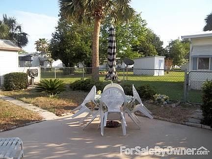 Fencned in patio area at back of propety : Storage shed to the rear left of photo