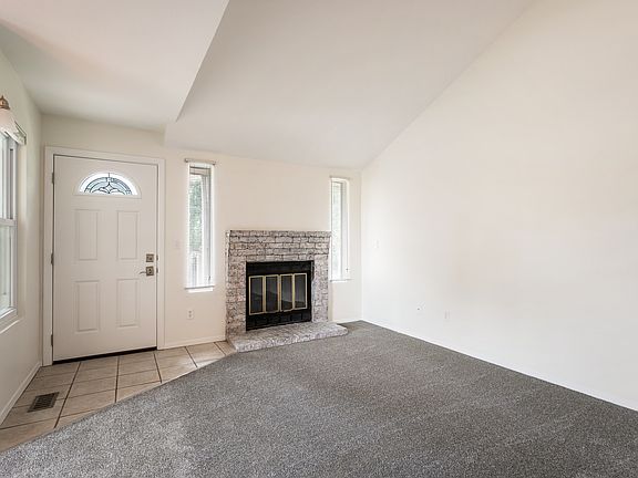 Open concept floor plan with living room and dining room. Vaulted ceilings.