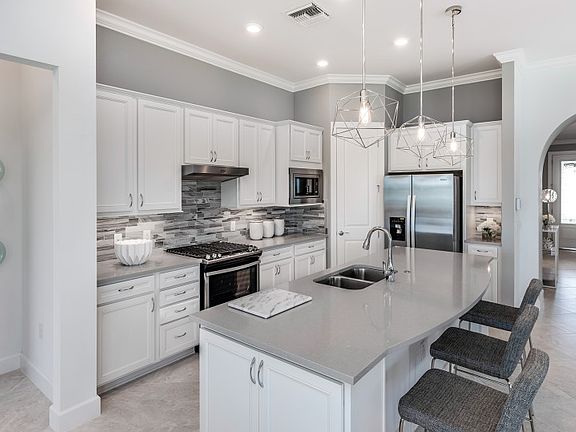 Thoughtfully designed kitchen with personalized upgrades, tile backsplash, stainless steel appliance