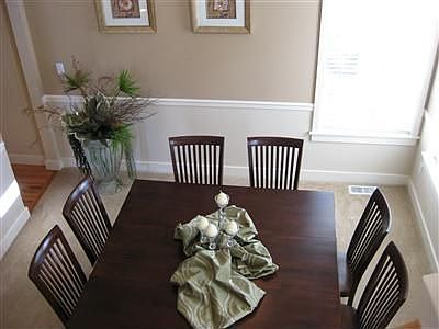 The sun drenched formal dining room is perfect for a large group. Wainscoating for that elegant feel