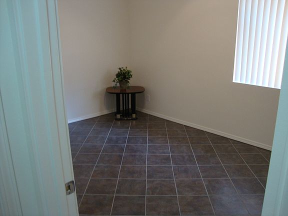 Guest bedroom has beautiful ceramic tile flooring, LED lighted ceiling fan, mirrored wardrobe closet with shelving, vertical blinds, natural sun light