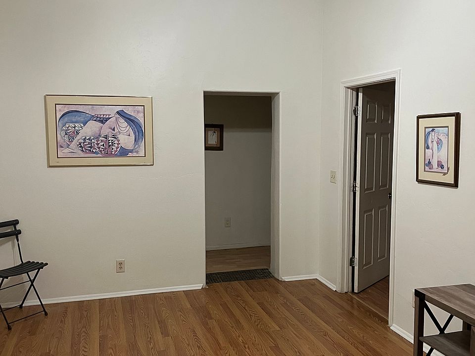 Skylights, ceiling fan and new hardwood floor in living room Door shown leads to kitchen/dining area and back bedroom.