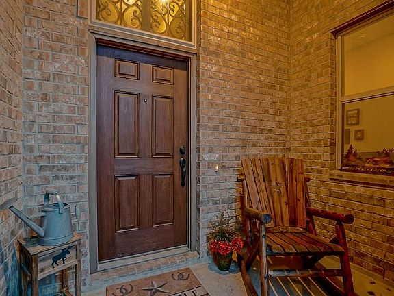 Quaint front porch with attractive door. Notice the transom window above the door allowing natural light in.