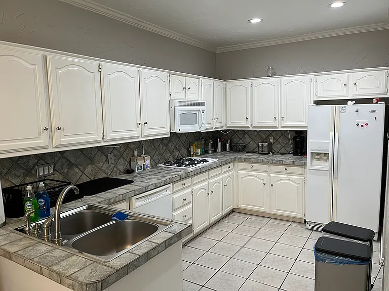 Large Kitchen with all appliances - oven, cooktop, refrigerator, microwave, & garbage disposal. Plenty of cabinet space. Shared space.