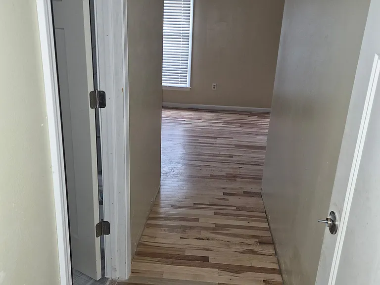 Entry into large primary suite with new hardwood floors and bathroom