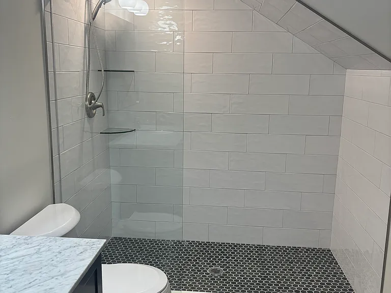 Walk-in shower with designer tile and custom glass door.