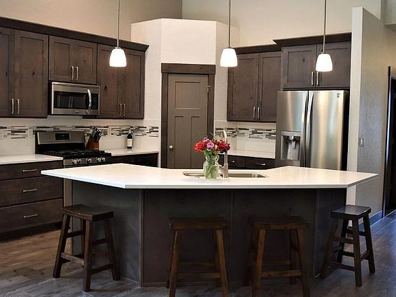 Gourmet kitchen with wrap around seating open to living space and dining