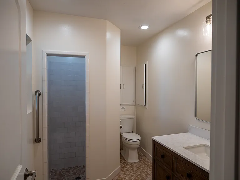 Fully remodelled bathroom with new deluxe vanity, mirror and fixtures. Unique step down shower allows for spa like feel.