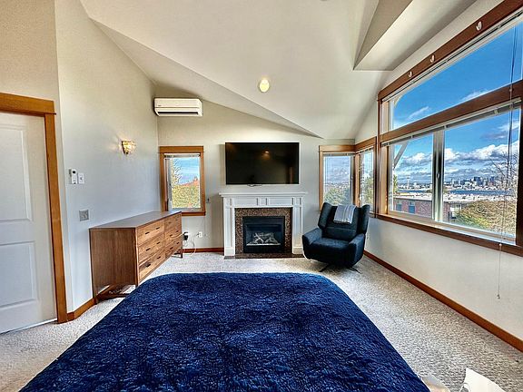 Primary bedroom: Enjoy your primary bedroom with vaulted ceilings, A/C, a gas fireplace and expansive views of the Seattle skyline.