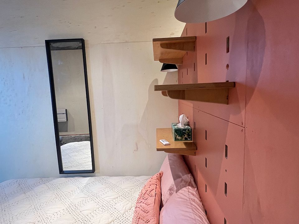 bed with wall light sconces and shelves.