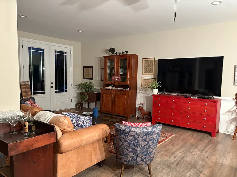 One side of the living room - the french doors open to the back yard, river and pergola.