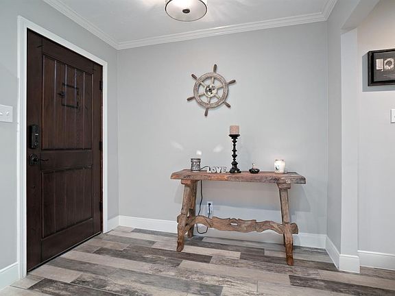 This entry is not only warm and inviting, but full of style with updated wood look tile floors and a gorgeous door.