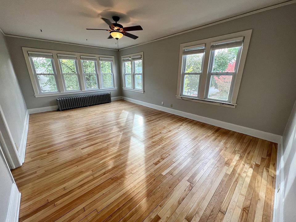 Enormous living room with refinished maple hardwood floors, fresh paint throughout, 8 large, newer windows, ceiling fan, and 9 1/2 foot ceilings