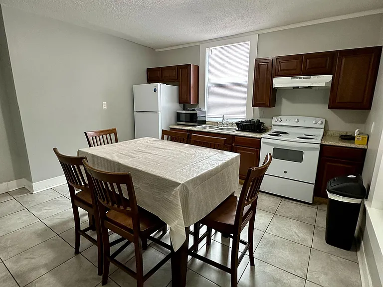 Eat-in kitchen with dining table, ample cabinet storage, and a full appliance set including range and refrigerator.