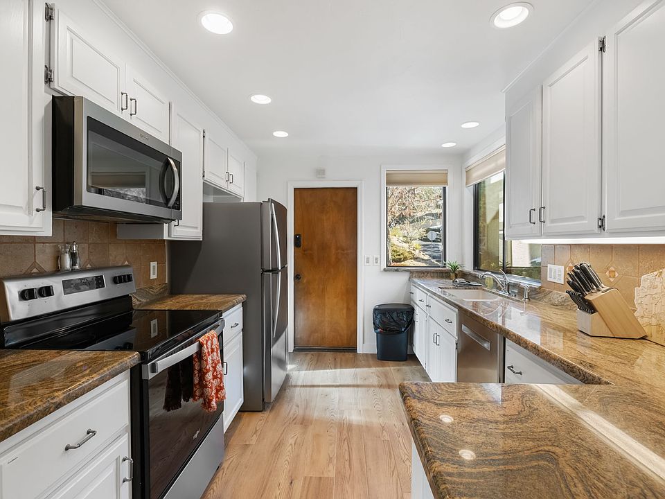 A modern, fully equipped kitchen with all the amenities seamlessly opens to the inviting living room.