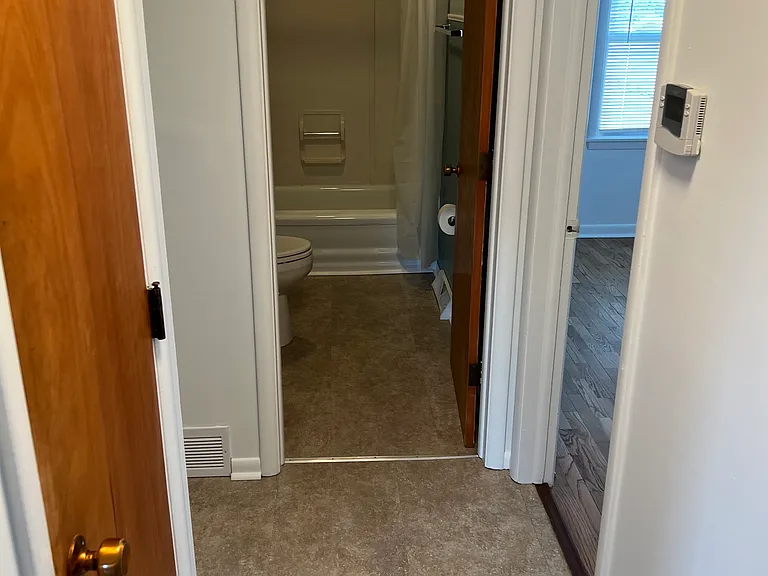 Hallway to the bathroom and bedrooms along with a coat closet.