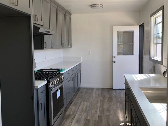 New kitchen with plenty of cabinets. New range, hood, quartz countertop, stainless steel sink, pull out faucet and light fixtures.
