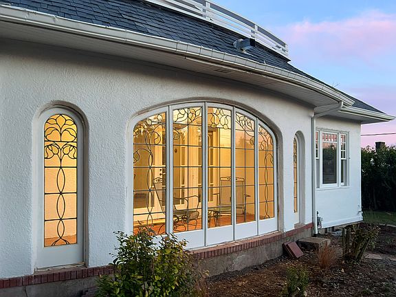 Unique sunroom has original stained glass windows and doors.
