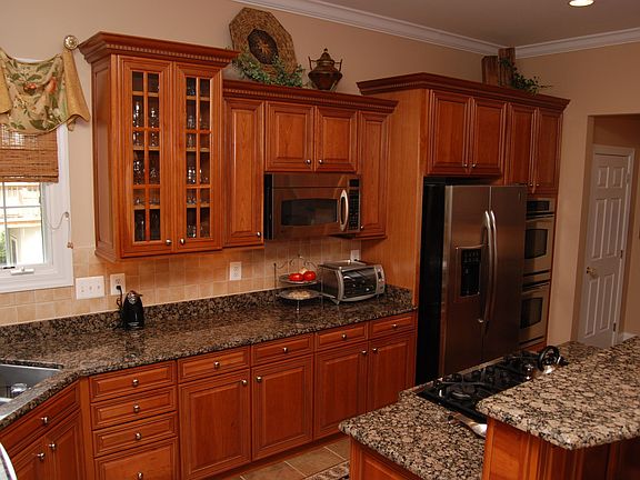 Gourmet Kitchen with center island cooktop, granite counters & cherry cabinets