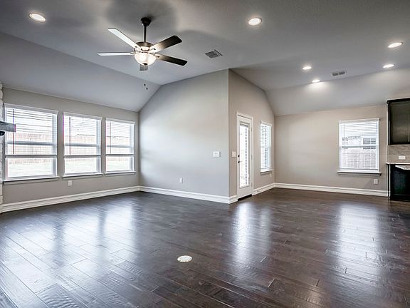 Gathering room with large windows, gorgeous flooring and fireplace.