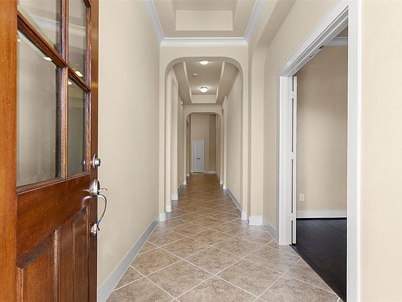 Welcome home! Large tile on diagonal, great arches and coffered ceilings.