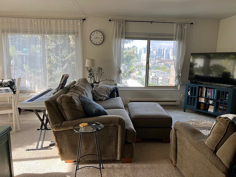 Living room and dining area with south and west view of Downtown Seattle, Space Needle, Lake Union, and east facing for balcony for morning sun into living area
