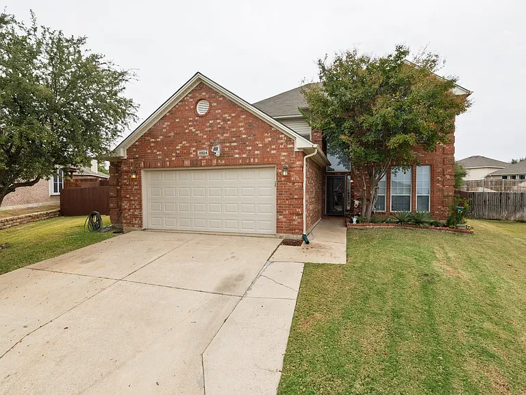 Welcoming brick home with a two-car driveway and front yard. Quiet neighborhood setting, private entrance, and easy parking for guests.