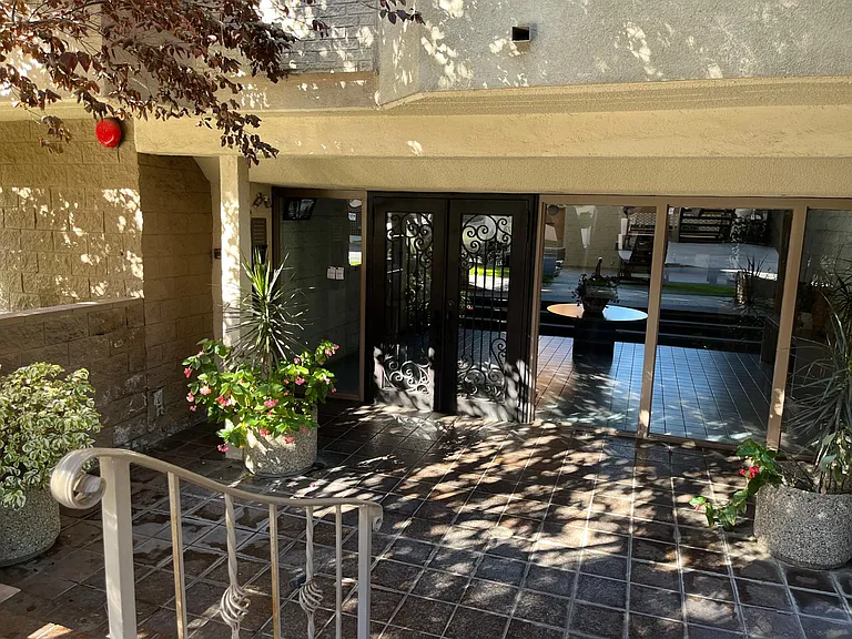 Trees and plants line the entry to the building main access