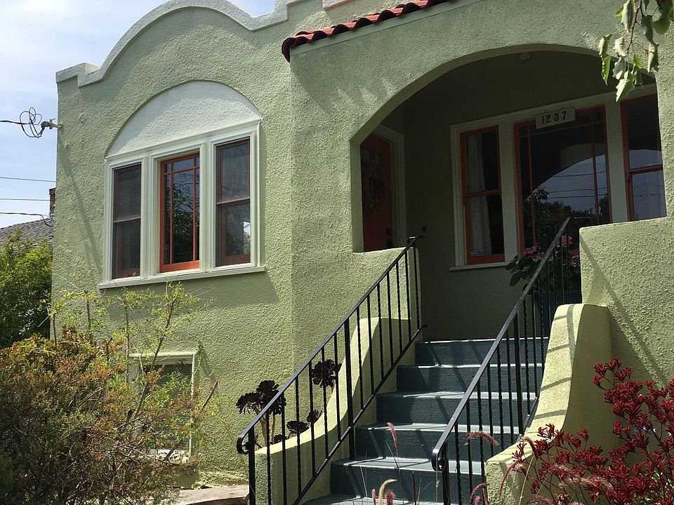Front exterior of home features mature landscaping and two street trees.