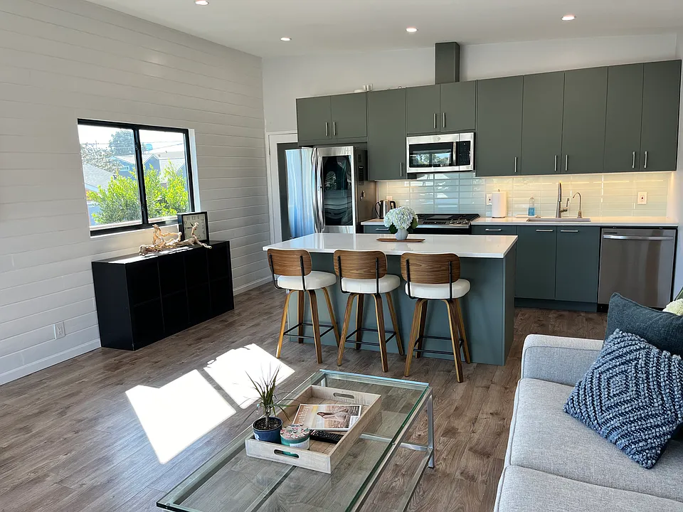 Kitchen island with seating for 3.
Island has electrical outlets for charging devices.