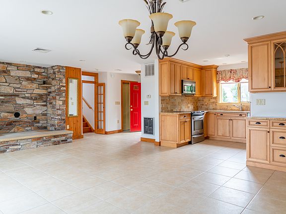 Underneath dining area chandelier facing kitchen, living room area and front door
